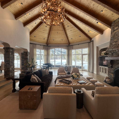 Window covering in living room with furniture, stone fire case, and white rug